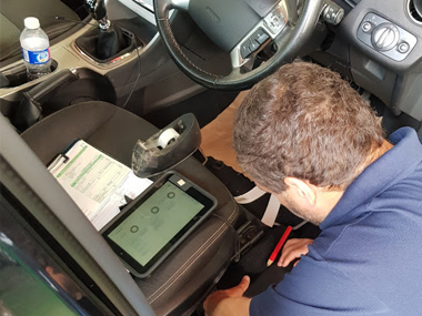 Engineer looks for stamped chassis number Engineer at ITV test